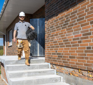 a worker at a construction site holds an electrical cable.